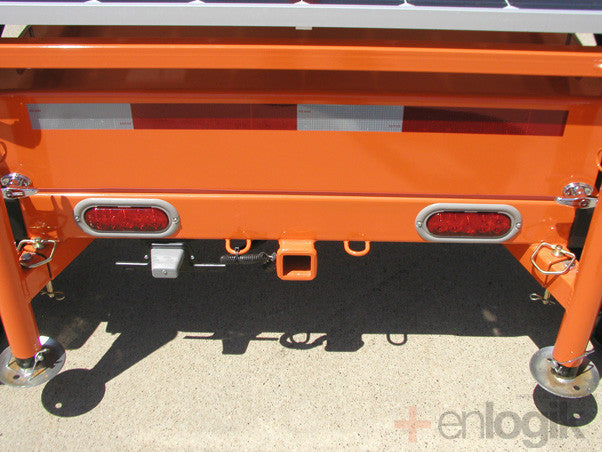 Here you see the rear view of the Worksite Hawk trailer. You can see the rear outriggers and drop leg jacks that extend to provide stability. You can also see that there is a rear receiver hitch and wiring that allows the trailer to be towed in tandem.